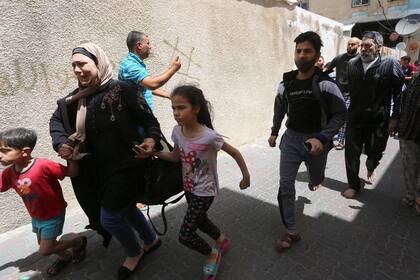 Palestinos evacuan un edificio blanco de los ataques aéreos israelíes en la Franja de Gaza. Israel llevó a cabo ataques aéreos en el enclave costero en respuesta a un aluvión de misiles disparados hacia Israel por el movimiento islamista Hamas