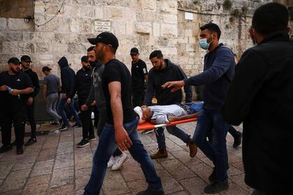 Palestinos evacuan un manifestante herido durante los enfrentamientos con fuerzas de seguridad israelíes, en la Puerta de los Leones