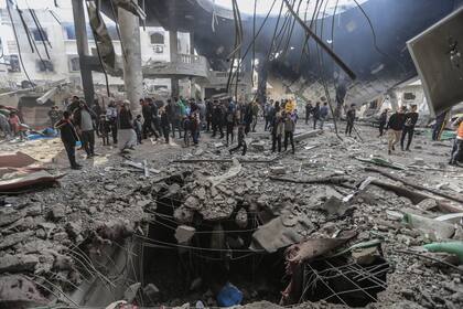 Palestinos inspeccionan las ruinas de la Mezquita Al-Huda, que fue destruida tras un bombardeo israelí en la ciudad de Rafah.
