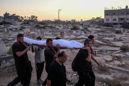Palestinos llevan a un muerto para ser sepultado en el cementerio en Deir al-Balah, Franja de Gaza (Foto AP/Abdel Kareem Hana)