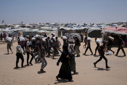 Palestinos llevan bolsas con comida y ayuda humanitaria en Rafah (Archivo)