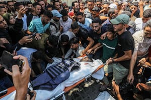 Palestinos llevan el cuerpo de un periodista que murió en un ataque israelí contra el Hospital Nasser en Khan Younis