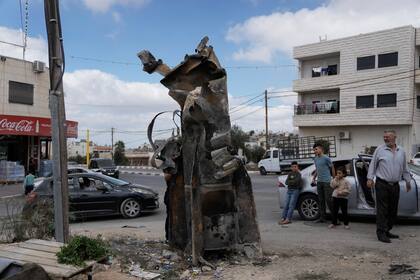 Palestinos observan los restos de un misil iraní interceptado por Israel, el 2 de octubre de 2024, en Hebrón, Cisjordania. (AP Foto/Mahmoud Illean, Archivo)
