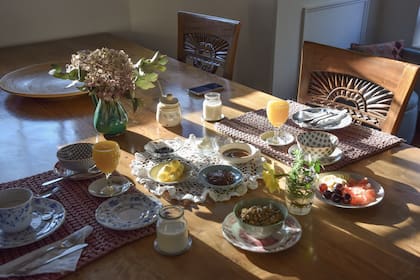 Pan horneado, mermeladas caseras, budines, scons, café, jugo de naranja exprimido, yogur casero, frutas frescas y granola en el comedor