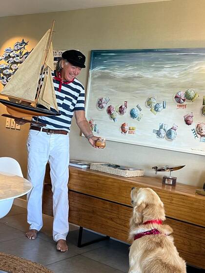 Pancho juega con Crack mientras sostiene un velero antiguo y un Ronson de colección (Mutate). Sobre el mueble (Occidente Studio), un trofeo de 1972 y detrás, un cuadro con sombrillas de la artista Mercedes Alsogaray (Matiz). "Pasé casi dos meses buscando cada uno de los objetos de este lugar. Necesitaba que tuviera mi impronta", cuenta.