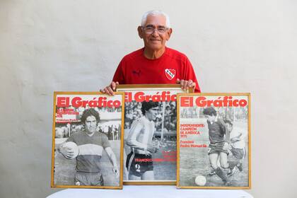 Pancho Sá en el patio de su casa, con algunos de los cuadros que decoran su living. 