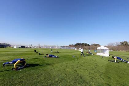 Panorámica de los jugadores de Boca haciendo ejercicios con distanciamiento social en la burbuja que el plantel realiza en Ezeiza. La aparición de 19 casos positivos de coronavirus obligó a suspenderla. El jueves, el plantel será hisopado.