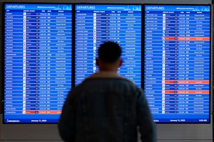 Pantalla de video muestra retrasos y cancelaciones de vuelos en un aeropuerto al este de Estados Unidos