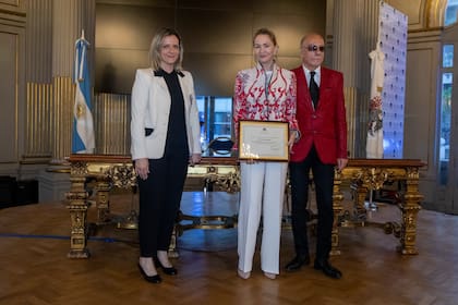 Paola recibe un diploma de reconocimiento de manos de Ornela Vanzillotta, directora general de relaciones internacionales y cooperación y de Luis Guzmán Castellanos, curador de la muestra “Antarctica, Melting beauty”.