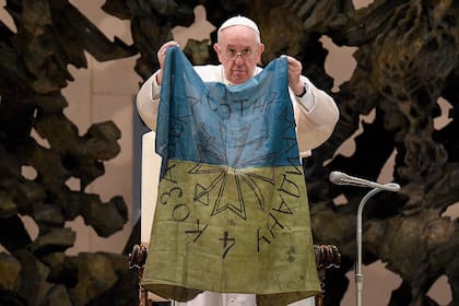 Esta foto tomada y distribuida por The Vatican Media, el 6 de abril de 2022, muestra al Papa Francisco mientras sostiene una bandera de Ucrania proveniente de la ciudad de Bucha