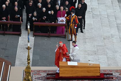 El cardenal italiano Giovanni Battista Re bendice el ataúd del Papa emérito Benedicto XVI, mientras el presidente alemán Frank-Walter Steinmeier y el arzobispo alemán Georg Gaenswein miran durante su misa fúnebre en la plaza de San Pedro en el Vaticano el 5 de enero de 2023