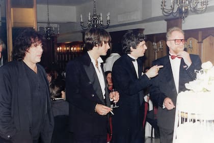 Pappo, Memi, Juanse y el productor de los Stones, Andew Oldham, rodean la torta de casamiento del cantante, en 1994