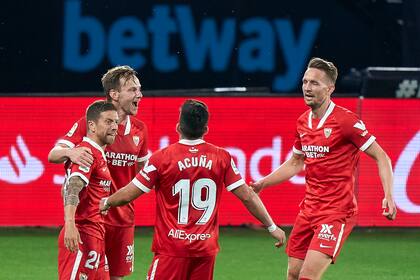 Papu Gomez del Sevilla FC celebra con Rakitic y Acuña después de marcar el cuarto gol de su equipo durante el partido ante Celta de Vigo (Foto de Jose Manuel Alvarez / Quality Sport Images / Getty Images)