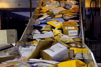 Paquetes en una cinta de distribución en una instalación de clasificación y procesamiento del Servicio Postal de Estados Unidos el jueves, 18 de noviembre de 2021, en Boston. (AP Foto/Charles Krupa)