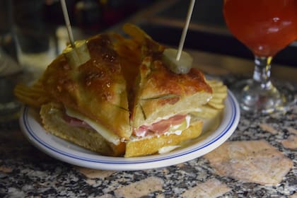 Para acompañar los cócteles, hay sándwiches en pan de focaccia, platitos y picadas