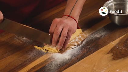 Para cortar pastas largas a cuchillo sin que la masa se pegue o se aplaste, el chef utiliza la técnica de la palmerita