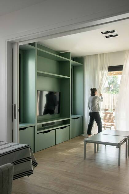 Para descontracturar este ambiente, que usan mucho los chicos, hicieron un mueble de MDF laqueado verde.