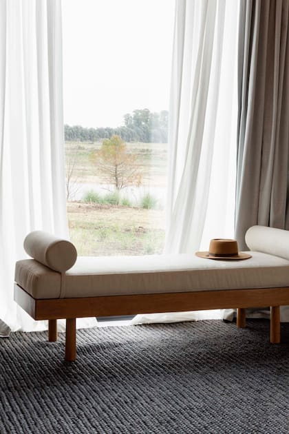 Para disfrutar todavía más de la vista abierta, equiparon el sector junto a la ventana: cortinas de gasa de algodón con blackout (Maru Bardó), alfombra (Mihran), chaise longue y espejo (Inés Coviello).