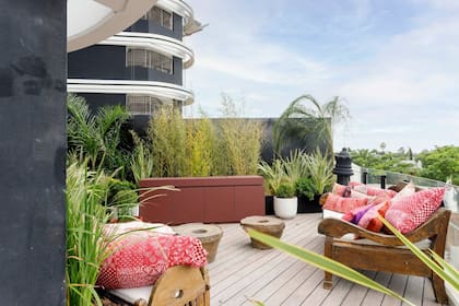 Para el balcón-terraza, las diseñadoras eligieron muebles de teca con almohadones y antiguos morteros de teca como mesitas de apoyo (todo de Desde Asia).