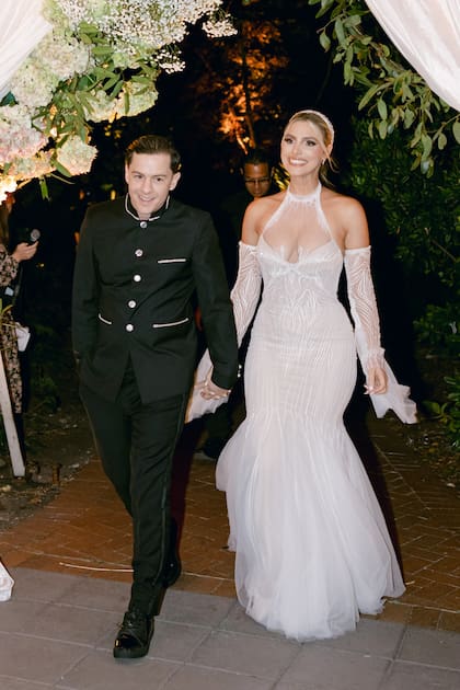 Para el banquete nupcial, la novia optó por un vestido de encaje de Julie Vino, con cuello halter, transparencias, espalda descubierta y falda de corte sirena.
