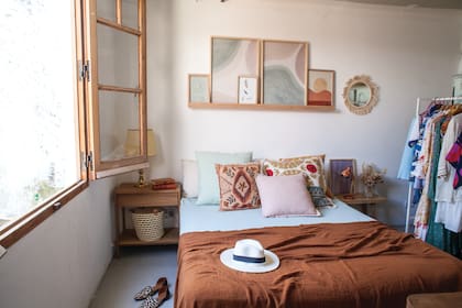 Para el dormitorio, también eligió colores tierra. Combinó almohadones pastel con otros pintados a mano (Ditrisio).