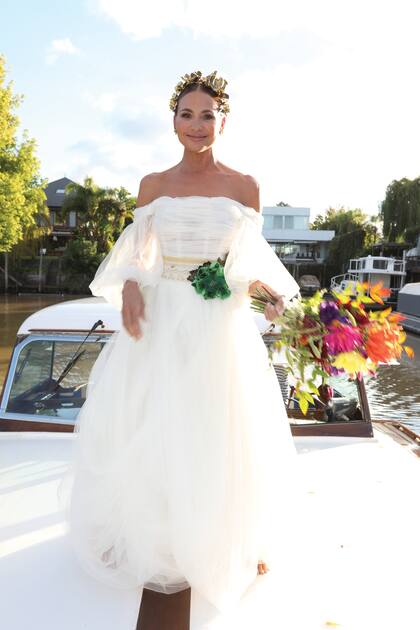 Para el gran día, Natalia eligió un vestido de tul de seda natural en color off white de inspiración celta, diseñado por Benito Fernández. Tenía un top off shoulder, una amplia falda con capas de tul y la cintura bordada en beige y dorado, con flores verdes de seda.