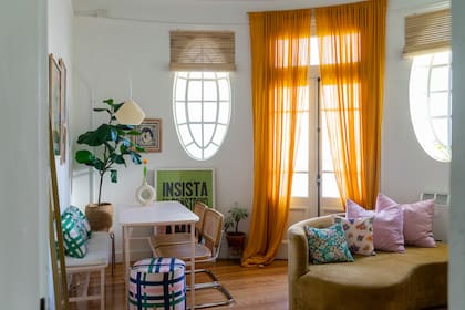 Para el living circular, eligieron un sillón curvo (Estée Deco) y almohadones con estampas de diseño propio. El puf también tiene su huella