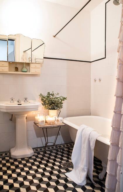 Para el piso eligió un dibujo de azulejos retro para mantener el clima de la casa. Un arreglo de eucaliptus (La Floreri), toalla blanca (Arco Iris) y velas (Love this Candle).