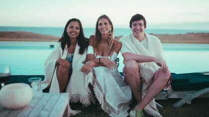 Para ellas y ellos, los chals de hilo blanco playeros son el objeto fetiche de la temporada. En la foto lo lucen lVeronica Nolazco , Delfina Passaglia y Bruno Quintana en el Sunset Las Garzas