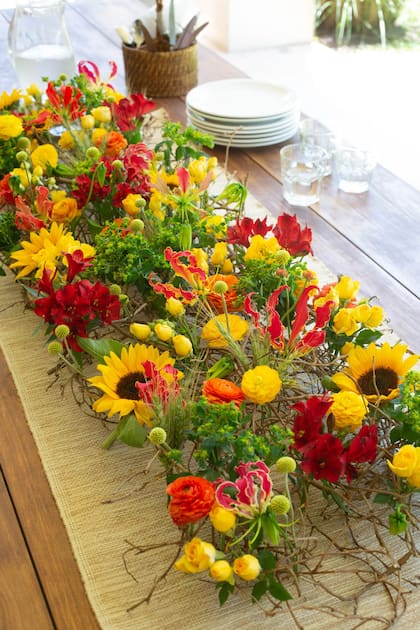 Para este arreglo informal, sostenido por una estructura natural,
se usó la paleta de los cálidos, muy típicos de la estación. Por su forma rectangular y tamaño generoso, puede usarse como centro de mesa. Las flores se hidratan en copas o tubitos de vidrio con agua, lo que permite una mayor duración del arreglo.