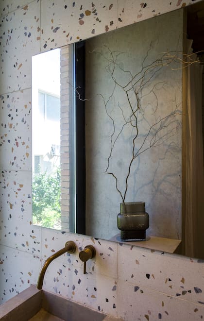 Para este toilette, eligieron aplicar terrazo (Quadri) a la pared, que tiene mesada de hormigón hecha en obra. Grifería (Ágata Faucets).