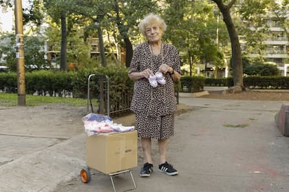 Tiene 90 años y sale a vender batitas de bebés en la plaza