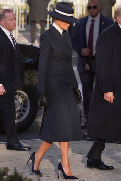 Para la ceremonia de jura en el Capitolio, Melania eligió un tapado entallado con doble abotonadura del neoyorquino Adam Lippes, falda, blusa blanca y stilettos de Manolo Blahnik, todo, en azul, y un sombrero canotier de Eric Javits con una cinta marfil.