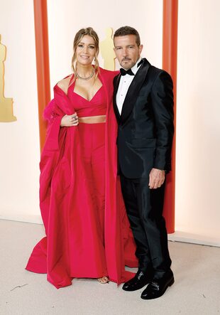 Para la ceremonia de los Oscar, Antonio Banderas y Nicole Kimpel lucieron equipos de la firma española Pedro del Hierro. El actor llevó un smoking negro en raso de seda y su novia, un crop top con espalda descubierta, palazzo de tiro alto y capa en fucsia.