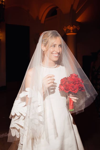 Para la ceremonia, Grace llevó un vestido con cuello a la base y velo de Oscar de la Renta que acompañó con un bouquet de rosas rojas.