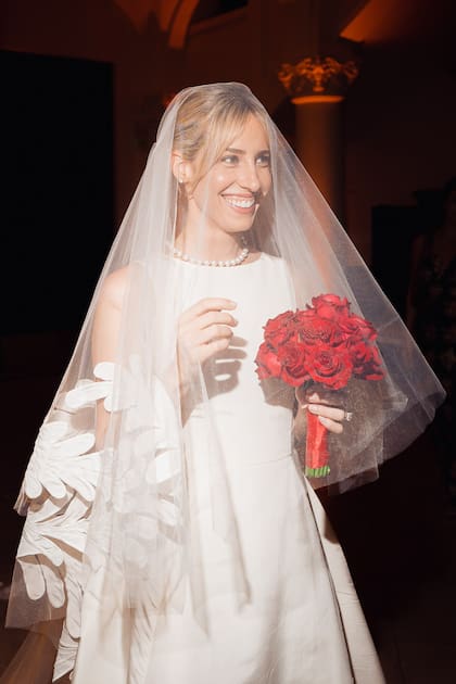 Para la ceremonia, Grace llevó un vestido con cuello a la base y velo de Oscar de la Renta que acompañó con un bouquet de rosas rojas.
