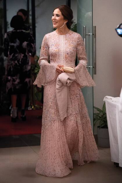 Para la comida
de recepción en Lagos, la
Reina eligió un vestido de
gala diferente: se trata de
un diseño de gasa plisada de
estampa floral, ribetes de
encaje y puños acampanados,
de Mikael Aghal, al que le
sumó un clutch de Serpui.