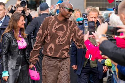 Para la ocasión, Marta Luisa eligió un conjunto de chaqueta y falda de cuero con abertura central que combinó con una blusa fucsia y cartera haciendo juego. Su futuro marido, en cambio, optó por un sweater con apliques de tela en tono chocolate que completó con pantalones cargos.