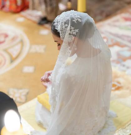 Para la solemnización de los votos, la futura princesa eligió un look nupcial en el que sustituyó el hiyab por un precioso velo bordado, a juego con el vestido, de manga larga y acabados refinados.