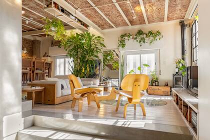 “Para que combine con la onda de la casa restauré el sillón de mi abuela sacándole el lustre a la madera”. Para evitar la tv se instaló un proyector en el área del living que permanece oculto cuando no se usa.