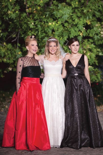 Para su casamiento, en 2014, Tweety llevó un vestido que cocreó con Fini Reynal, con quien trabajó durante años: era de encaje Chantilly con mangas línea A, cintade terciopelo en el talle y escote profundo en V. El detalle: la tiara Embiricos, una alhaja que había pertenecido a Mosha, su abuela materna e hija del armador griego George Embiricos. En la foto está con Marina, su madre y amiga de Christina Onassis, y su hermana mayor, Carminne.