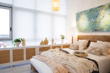 Para su departamento en Experiencia Living 2023 hicieron un larguísimo mueble con puertas y cajones en esterilla de ratán que iba de un extremo al otro de su amplio monoambiente