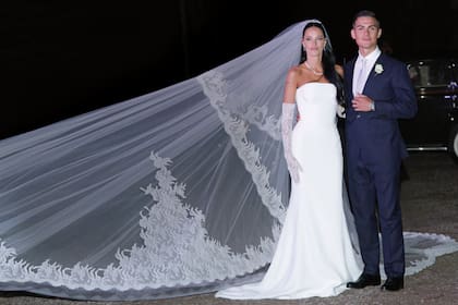 Para su gran día, Oriana eligió un vestido strapless de corte sirena con guantes largos de encaje y un imponente velo catedral bordado a mano, todo de Dolce & Gabbana. Acompañó con una gargantilla y pendientes de oro y brillantes de la joyería Damiani. Paulo lució un traje azul hecho a medida por la casa Battistoni.