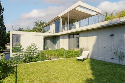 Para suavizar el aspecto compacto del hormigón, en el remate de la casa se ahuecó la losa del semicubierto. Reposera (Brauer).