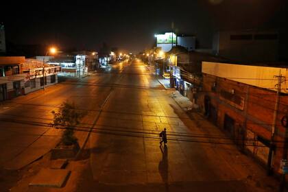Un hombre cruza una avenida vacía de Eusebio Ayala durante un toque de queda para frenar la nueva pandemia de coronavirus en Asunción