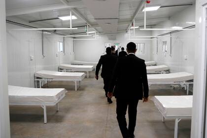 Los guardias de seguridad siguen al presidente de Paraguay mientras recorre una nueva instalación médica que recibirá a personas con COVID-19 en Itagua, Paraguay