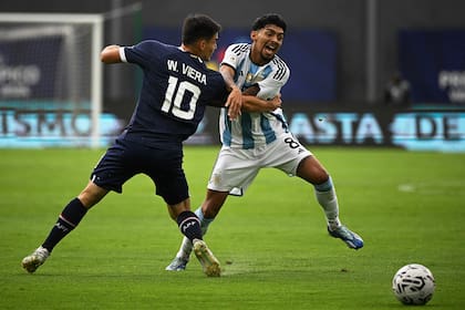 Paraguay's Wilder Viera (L) and Argentina's Cristian Medina (R) fight for the ball during the Venezuela 2024 CONMEBOL Pre-Olympic Tournament football match between Argentina and Paraguay at the Brigido Iriarte stadium in Caracas on February 8, 2024. (Photo by Federico Parra / AFP)