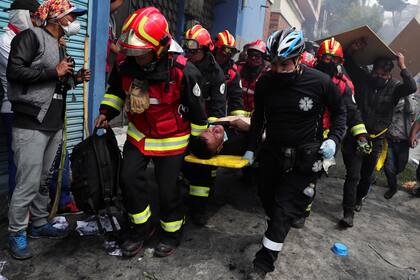 Paramédicos cargan un manifestante herido durante las protestas contra las medidas del presidente Lenin Moreno
