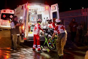 Paramédicos llevan a un migrante herido después de un incendio que mató a decenas de migrantes, en la estación de inmigración en Ciudad Juárez, estado de Chihuahua el 28 de marzo de 2023