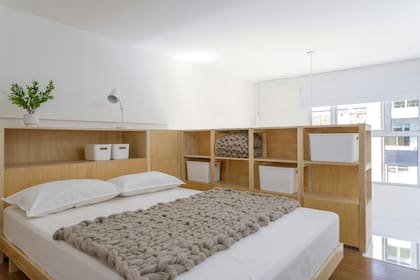 Paraná Muebles transformó la baranda del entrepiso en un mueble en L que funciona como respaldo, mesa de luz y placard.